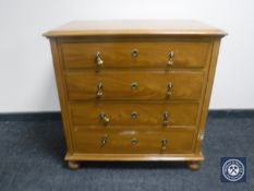 A 20th century stained pine four drawer chest on bun feet