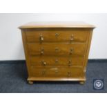 A 20th century stained pine four drawer chest on bun feet