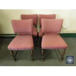 Four oak dining chairs in a red patterned fabric