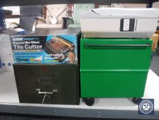 A plastic portable storage box together with a boxed tile cutter,