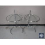 A pair of circular adjustable metal lamp tables