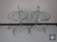 A pair of circular adjustable metal lamp tables