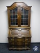 A continental oak serpentine fronted bureau bookcase