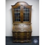 A continental oak serpentine fronted bureau bookcase