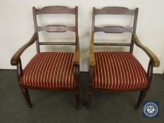 A pair of mahogany 20th century armchairs in red striped fabric