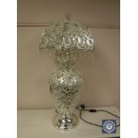 A highly ornate white metal and crystal drop table lamp with revolving shade.