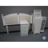 A white headboard, three drawer chest,