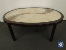An oval mahogany coffee table with stone panel insert