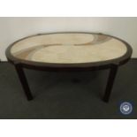 An oval mahogany coffee table with stone panel insert