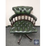 A green button leather low backed office chair.