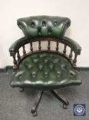 A green button leather low backed office chair.