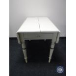 An antique painted pine drop leaf kitchen table