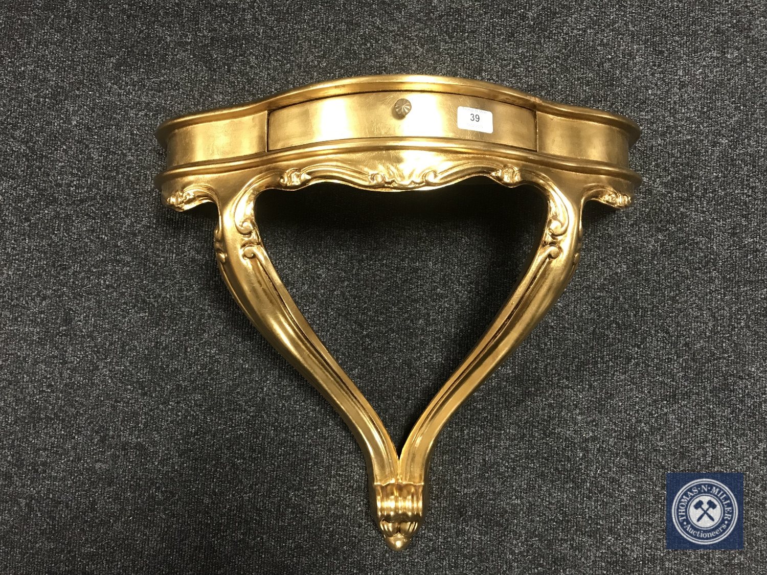 A gilt wall shelf fitted with a drawer