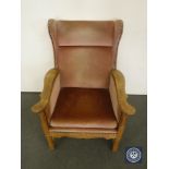 A continental oak wing back chair in pink fabric