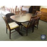 A mahogany extending dining table with leaves and six rail back chairs