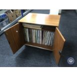 A teak double door record cabinet containing LP's