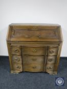 A continental oak serpentine fronted three drawer bureau