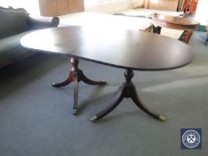 An oval mahogany twin pedestal table