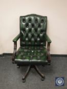 A green button leather high backed office chair.