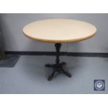 A circular table on a four way cast iron base