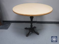 A circular table on a four way cast iron base