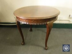A circular antique mahogany occasional table on claw and ball feet
