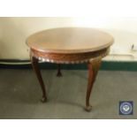 A circular antique mahogany occasional table on claw and ball feet