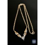 A two-tone gold diamond set necklace, a central brilliant-cut diamond of approximately 0.