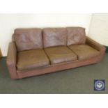 A mid 20th century brown leather three-seater settee