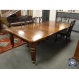 A Victorian mahogany extending dining room table, on reeded legs, with two leaves,