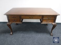 A reproduction mahogany writing desk fitted five drawers on claw and ball feet