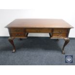 A reproduction mahogany writing desk fitted five drawers on claw and ball feet