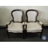 A pair of contemporary mahogany armchairs in white floral fabric