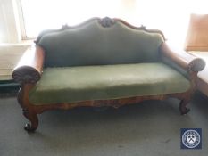 An antique continental mahogany framed settee in green fabric