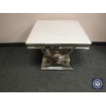A contemporary polished steel lamp table with white polished stone top,