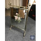 An early 20th century brass mirrored fire screen