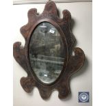 A 20th century mirror in tooled leather frame