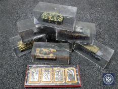 A box of seven model tanks in display cases and a set of four lighters