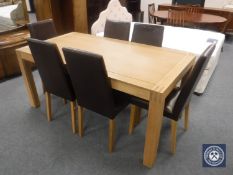 A contemporary oak dining table and six brown leather upholstered chairs