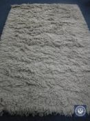 A hand knotted shaggy beige rug, 180 cm x 270 cm, rrp £681.