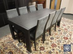 A contemporary black ash dining table together with eight chairs upholstered in grey suede,