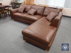 A brown leather corner suite and three scatter cushions