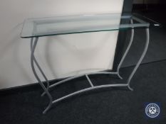 A glass-topped metal console table