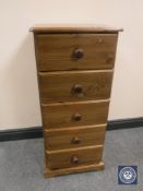 A narrow pine five-drawer chest