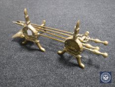 A three-piece brass companion set and two brass fire dogs