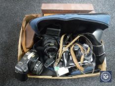 A box of cased binoculars, leather case cine-camera, camera bag, cameras including Zenit E,