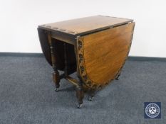 A 20th century carved oak drop leaf table