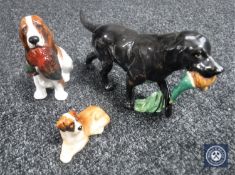 A Royal Worcester figure of a black Labrador with pheasant, together with two Royal Doulton figures,