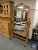 A late 19th century satinwood cheval mirror, with twin candle sconces, raised on ceramic castors,