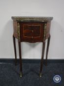An inlaid mahogany three-drawer bedside stand with gallery and gilt-metal mounts